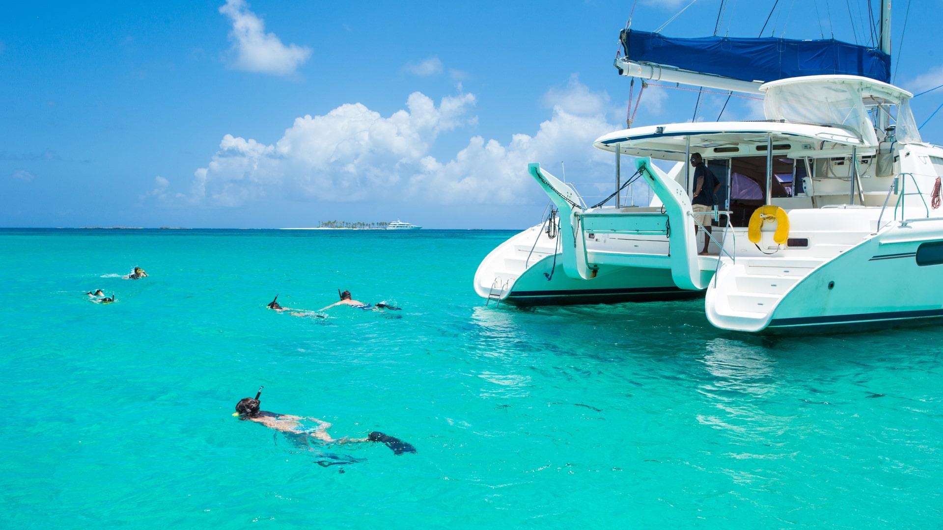Catamaran and snorkelers in turquoise Bahamian water